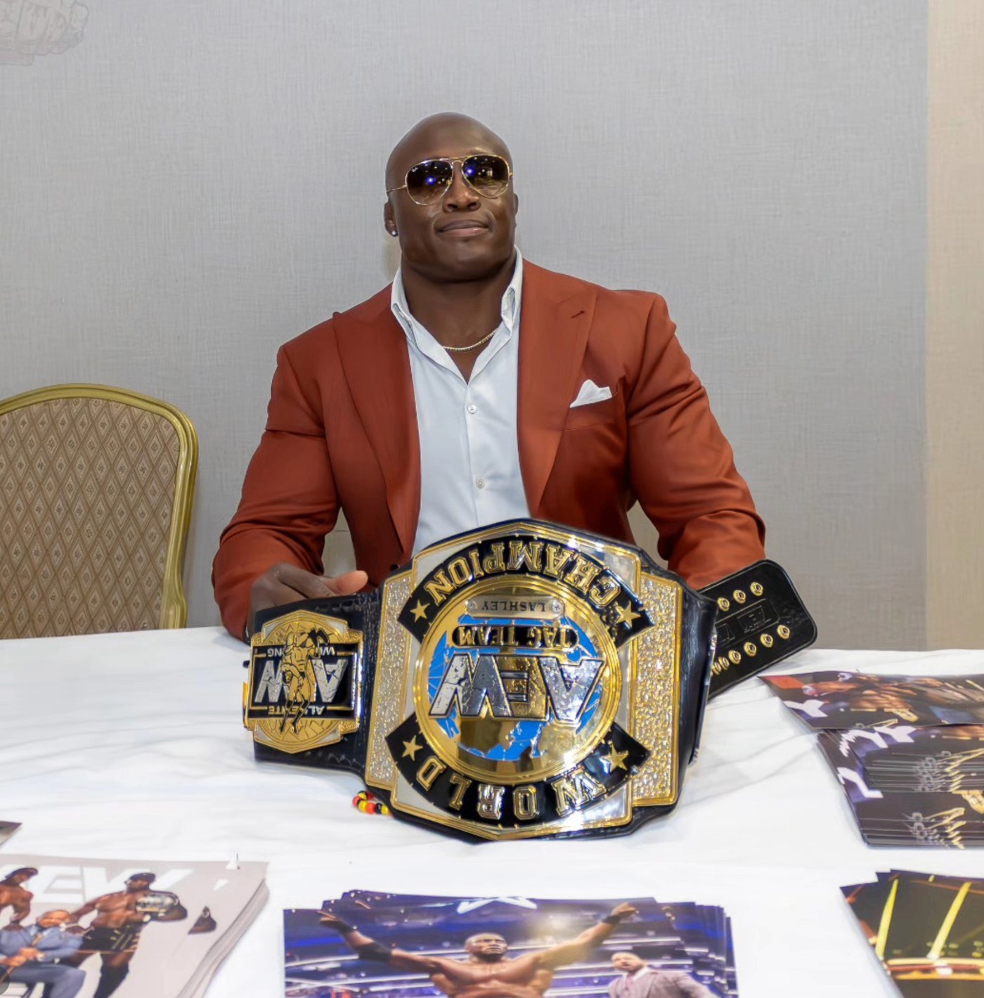 Bobby Lashley seated at a table with a championship belt